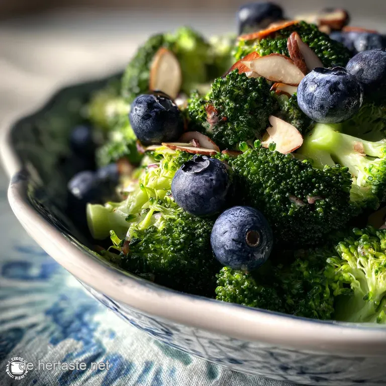 Elegant serving of bright green broccoli salad speckled with juicy blueberries and slivered almonds, showcasing freshness ...