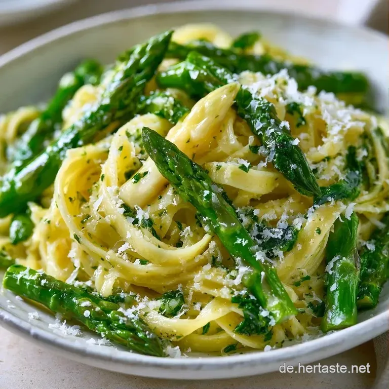 Elegant angerichtete Pasta mit zarten gr&uuml;nen Spargelspitzen, garniert mit Kr&auml;utern auf einer dunklen Keramikplatte.